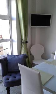 a room with a chair and a table with a laptop at Deluxe Seaside Apartment Ground Floor with Private Entrance and Patio in Bundoran