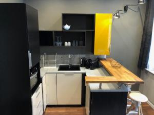 a small kitchen with a counter and a yellow cabinet at My Little Home - Le Vieux Lille de Rousseau in Lille