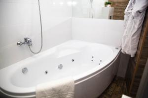 a white bath tub in a bathroom with white tiles at Rent of Apartments in Kharkiv in Kharkiv