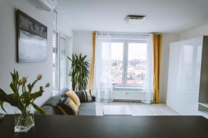- un salon avec un canapé et une fenêtre dans l'établissement Design apartment, the city centre close to the health spa, à Piešťany