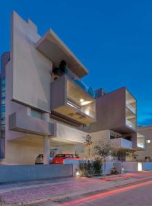 a large white building with a car parked in front of it at Verde Apartments in Athens