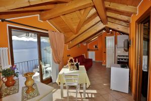 a kitchen and living room with a table and chairs at CasAle Fe-Wo - Appartamenti con vista Lago in Cannero Riviera