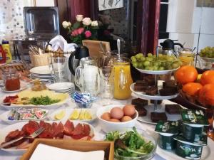 ein Tisch mit Teller mit Lebensmitteln, Eiern und Obst in der Unterkunft Teytz Apartments in Prag