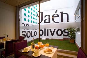 um restaurante com uma mesa com comida em frente a uma janela em Hotel Europa em Jaén