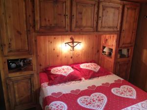 sypialnia z łóżkiem z czerwoną kołdrą w obiekcie L'ancolie w mieście Briançon