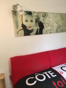 a picture of a girl on the wall above a red couch at Romantic getaway in the heart of Amalfi in Amalfi