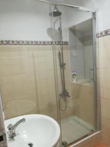 a shower with a glass door next to a sink at 100% Lisbon in Lisbon +14 photos