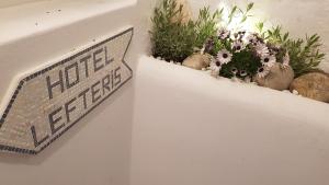 a sign on a wall with flowers and plants at Lefteris in Mýkonos City