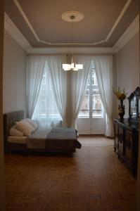 a bedroom with a bed and a large window at Ada Aparthouse in Wrocław