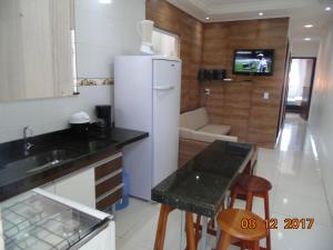 cocina con nevera, mesa y sillas en Propriedade Silva en Gamboa