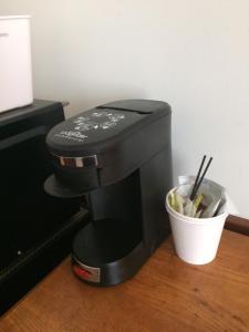 una macchinetta del caffè seduta accanto a una tazza di caffè di Atlantic Coast Inn a Ellsworth