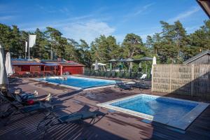a swimming pool on a deck with two loungers at Ljugarn Semesterby in Ljugarn