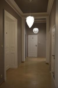 un pasillo vacío con puertas blancas y una lámpara de araña en Ada Aparthouse, en Wroclaw