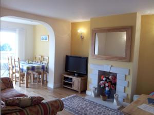 a living room with a fireplace and a television at Little Gem in Weymouth