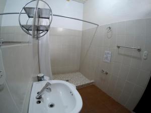 een kleine badkamer met een wastafel en een douche bij Casa Brenes in Matagalpa