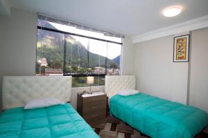 a bedroom with two beds and a large window at Hotel California Calca in Calca