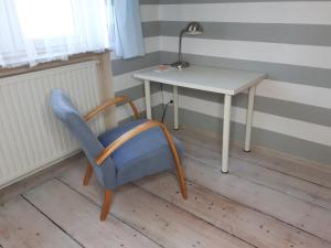グリヴィツェにあるApartament Zwycięstwaの白いテーブルの横に青い椅子