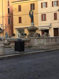 a fountain in the middle of a street with a building at Residence LA FORTUNA in Fano