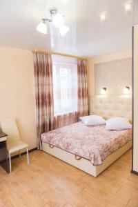 ウスリースクにあるFlagmanのベッドルーム1室(ベッド1台、窓、椅子付)