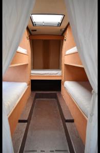 an empty room with two bunk beds and a window at Giljanes Hostel in Sandavágur