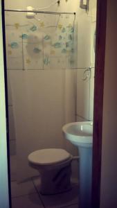 a bathroom with a toilet and a sink at Pousada Maia in Itaúnas