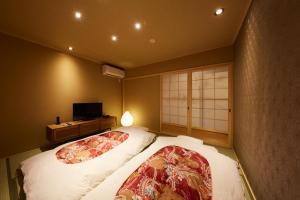 京都市にある鈴 宮川町 椿のベッド2台とテレビがあるホテルの部屋