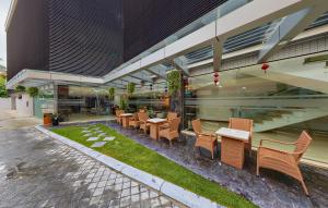 a restaurant with tables and chairs in front of a building at Le Indochina Hotel in Bắc Ninh