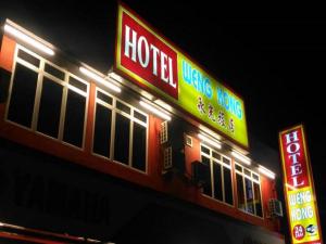 a hotel with neon signs on the side of it at Weng Kong Hotel in Slim River