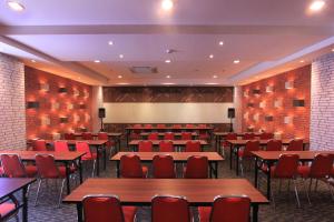 a conference room with tables and chairs and a projection screen at Uniq Hotel in Yogyakarta