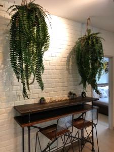 a table with two potted plants hanging from a brick wall at CK cottage @ Khao Yai in Pak Chong