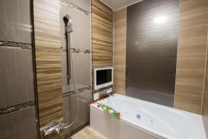 bagno con vasca e televisore di ホテル アンジュエトワール 堺 - Adult Only a Sakai