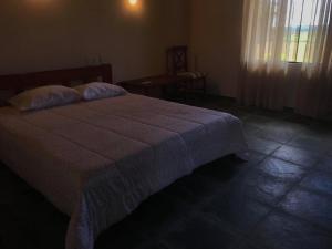 a bedroom with a bed with a blanket on it at Carlos Franco Country Golf in Arroyos y Esteros