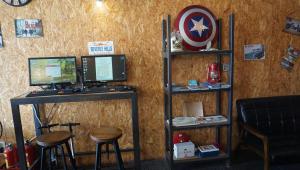 a computer desk with two monitors and two stools at Lovely Bean Hostel in Hualien City