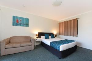 a hotel room with a bed and a chair at Motel in Nambour in Nambour