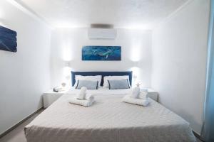a white bedroom with a large bed with two pillows at 330 Holiday Apartments Manarola in Manarola