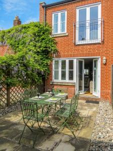 einen Tisch und Stühle vor einem Backsteinhaus in der Unterkunft Shell Cottage in Aldeburgh