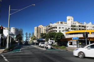 a city street with cars parked on the side of the street at Caribbean Resort in Mooloolaba