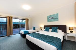 a hotel room with two beds and a balcony at Motel in Nambour in Nambour