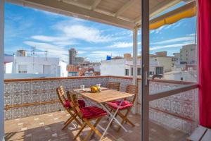 balkon z drewnianym stołem i krzesłami na dachu w obiekcie Apartment Calle Larga w mieście Fuengirola