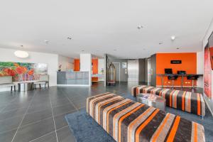 a living room with two couches and a kitchen at Abode Tuggeranong in Canberra