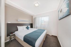 ein Schlafzimmer mit einem großen Bett in einem Zimmer in der Unterkunft Abode Tuggeranong in Canberra