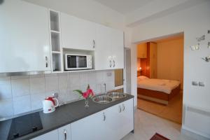 kuchnia ze zlewem oraz pokój z łóżkiem w obiekcie Apartments Popo w mieście Starigrad-Paklenica