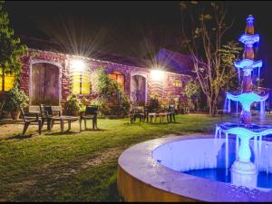 une maison avec une fontaine dans la cour la nuit dans l'établissement Shannu's Ranch Inn, à Pushkar