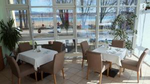 ein Restaurant mit zwei Tischen und Stühlen und einem großen Fenster in der Unterkunft Hotel Christine in Radolfzell am Bodensee