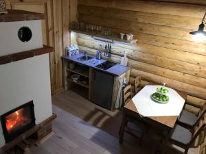a kitchen with a stove and a table and a fireplace at Manka Kisrönkház in Ispánk