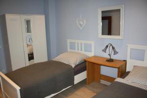 ein Schlafzimmer mit zwei Betten und einem Tisch mit Lampe in der Unterkunft Fewo Lirich in Oberhausen