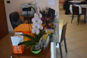 einen Glastisch mit einer Blumenvase darauf in der Unterkunft Alloggio Le Macine in Ferrara