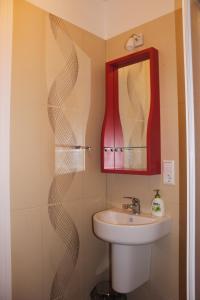 La salle de bains est pourvue d'un lavabo et d'un miroir. dans l'établissement Martas Nams, à Ventspils
