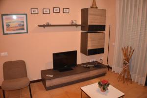 アンポスタにあるApartament Montserrat Eucaliptus 3のリビングルーム(テレビ、椅子付)