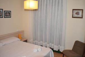 アンポスタにあるApartament Montserrat Eucaliptus 3のベッドルーム1室(ベッド1台、椅子、窓付)